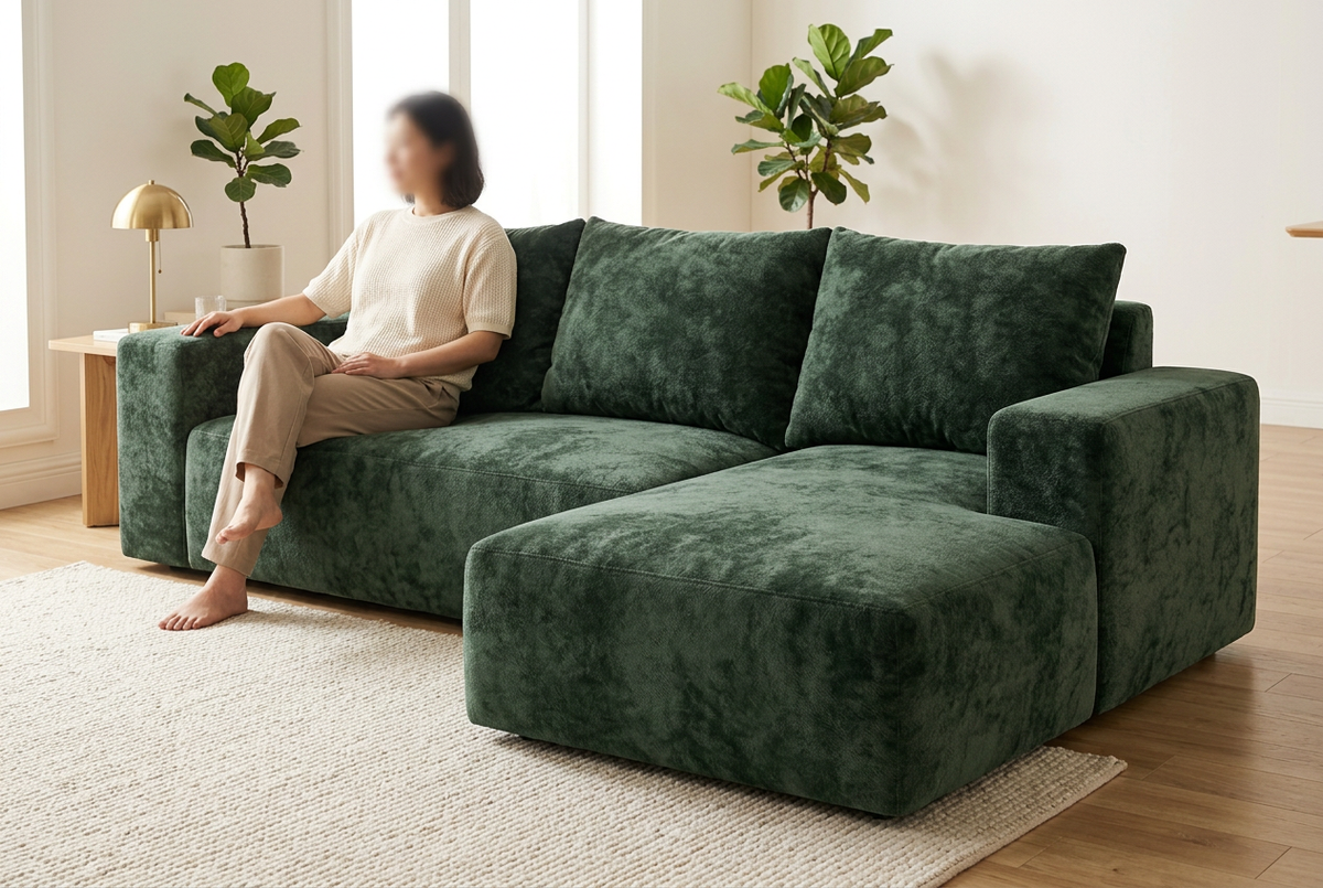 Canapé K28 vert dans un salon avec une personne assise